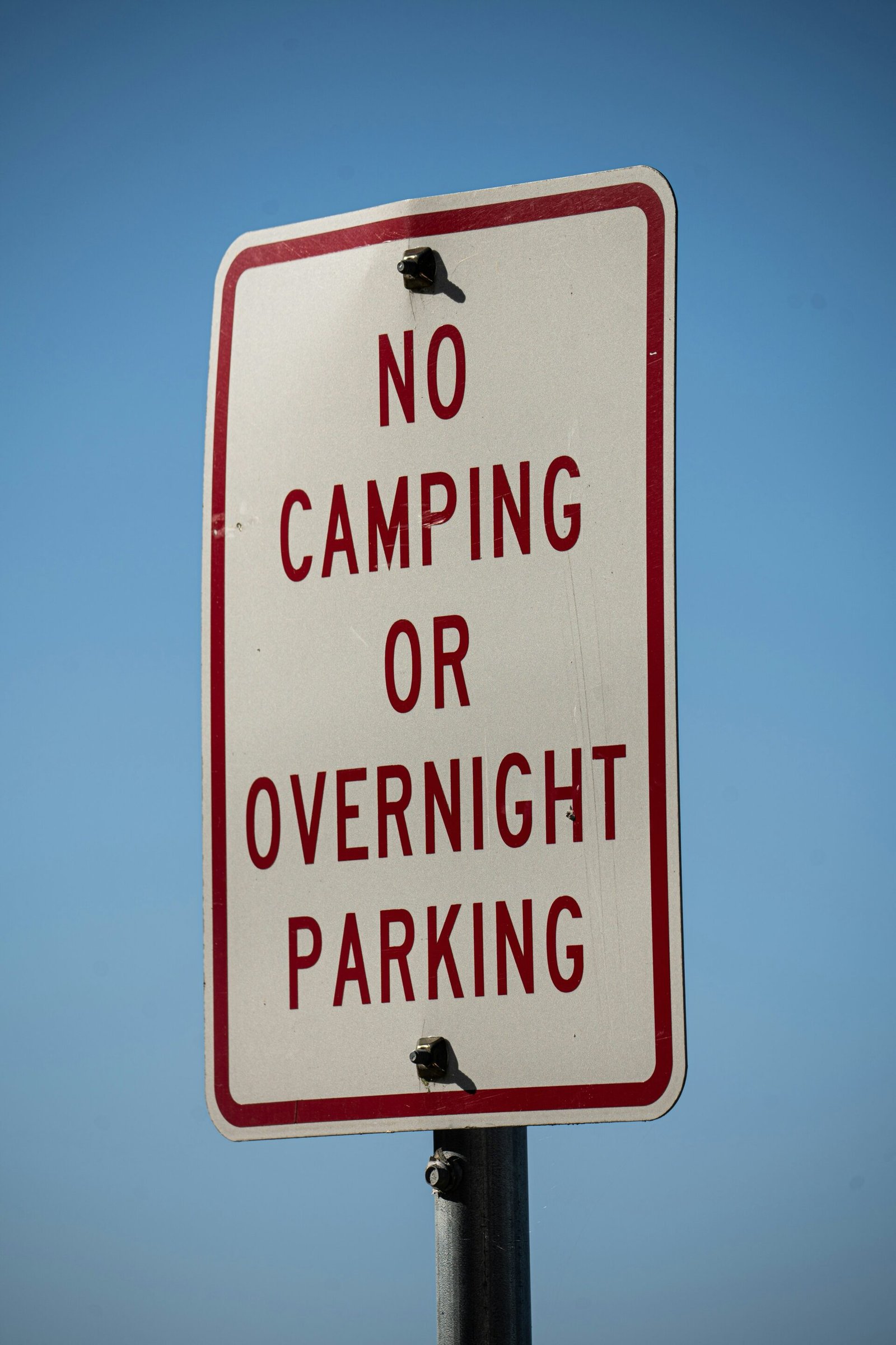 a no camping or overnight parking sign on a pole